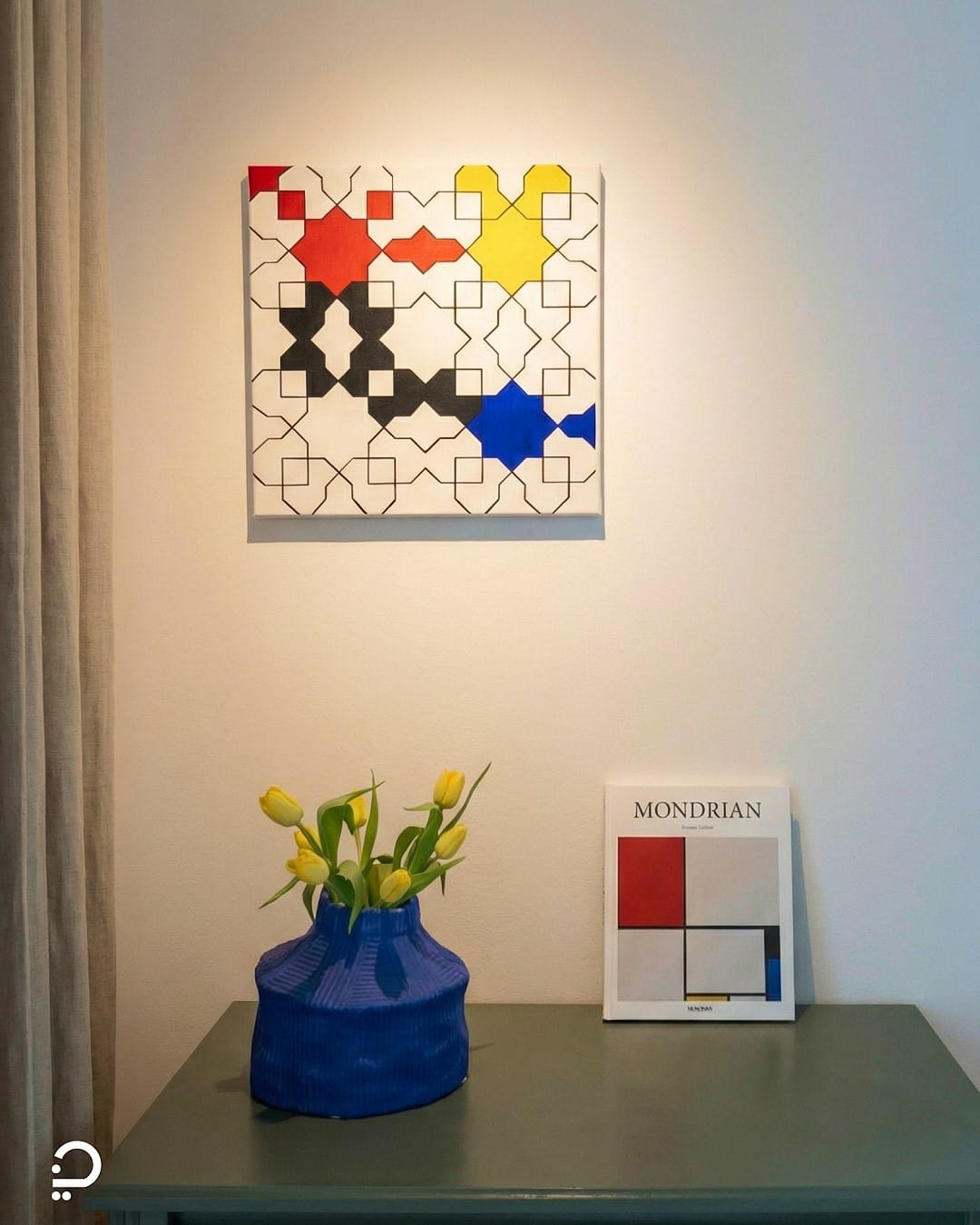 Modern geometric wall art inspired by Islamic patterns, styled with books and objects in a contemporary interior