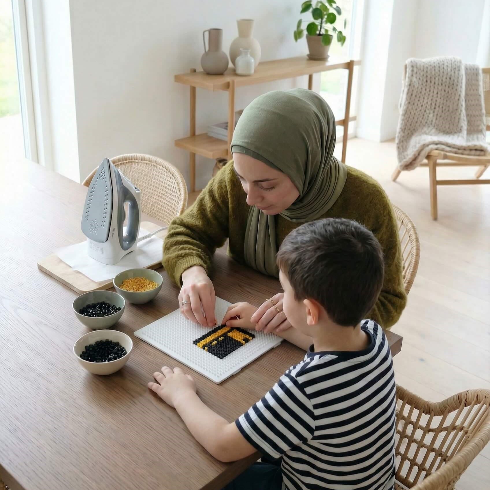 Mother and young child assembling a miniature Kaaba using black and yellow Perler beads.
