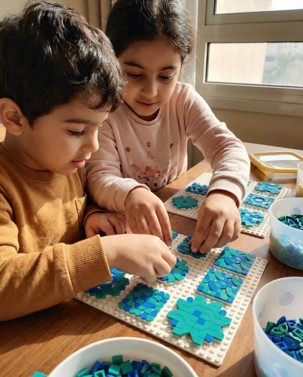 Two children creating Islamic geometric tile patterns with LEGO dots on a baseplate as a screen-free art activity