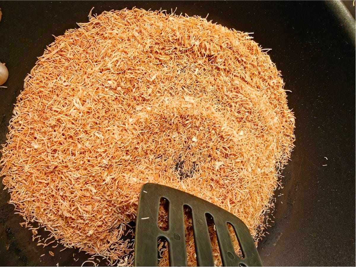 Toasting kataifi pastry in a dry pan until golden and crisp for chocolate kataifi salami.