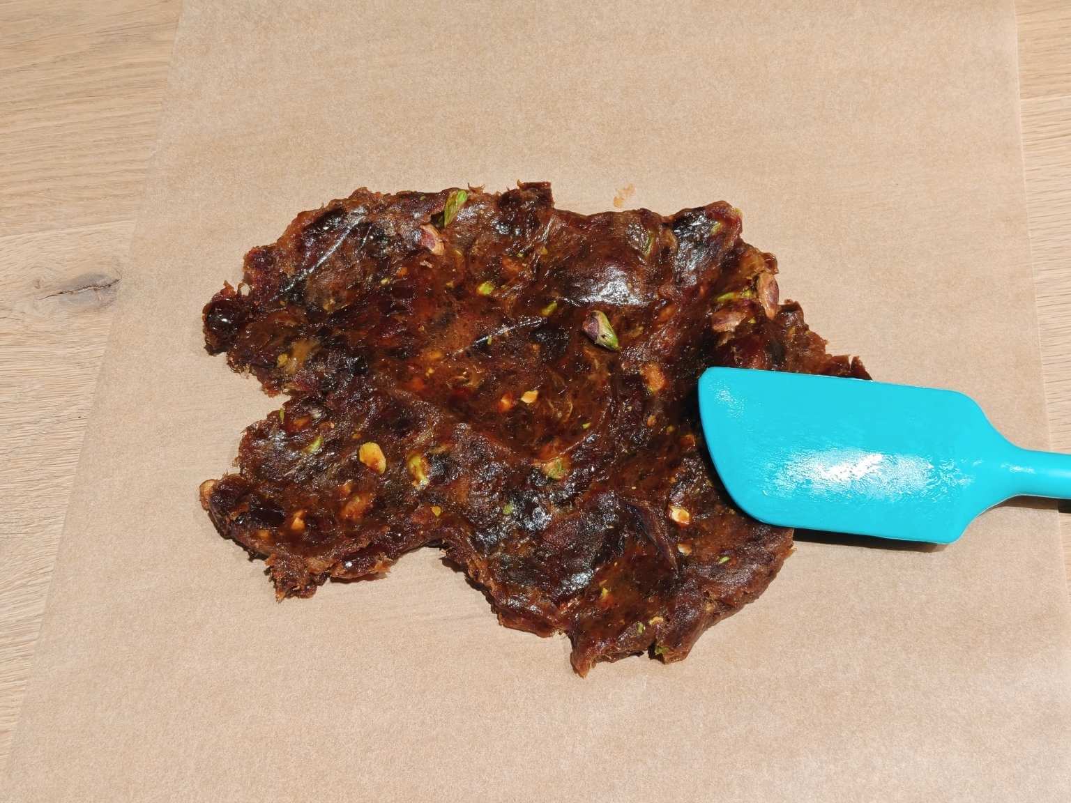 flattening pistachio date mixture on baking paper