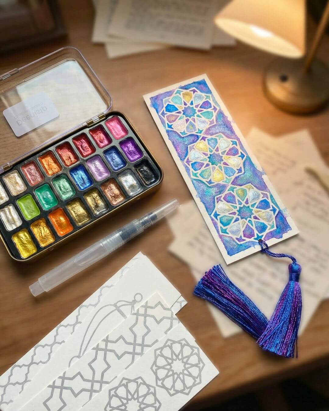 Deenista Islamic shimmer watercolor kit with pearlescent paints, refillable water brush, Islamic bookmark cards, and a finished geometric bookmark with tassel.