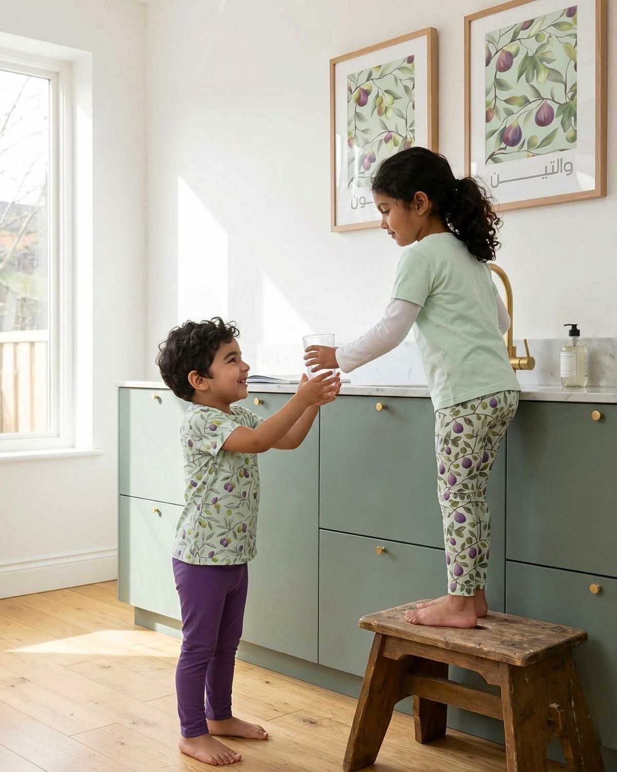 Children wearing Deenista fig & olive kidswear in a bright home with matching botanical Islamic wall art.