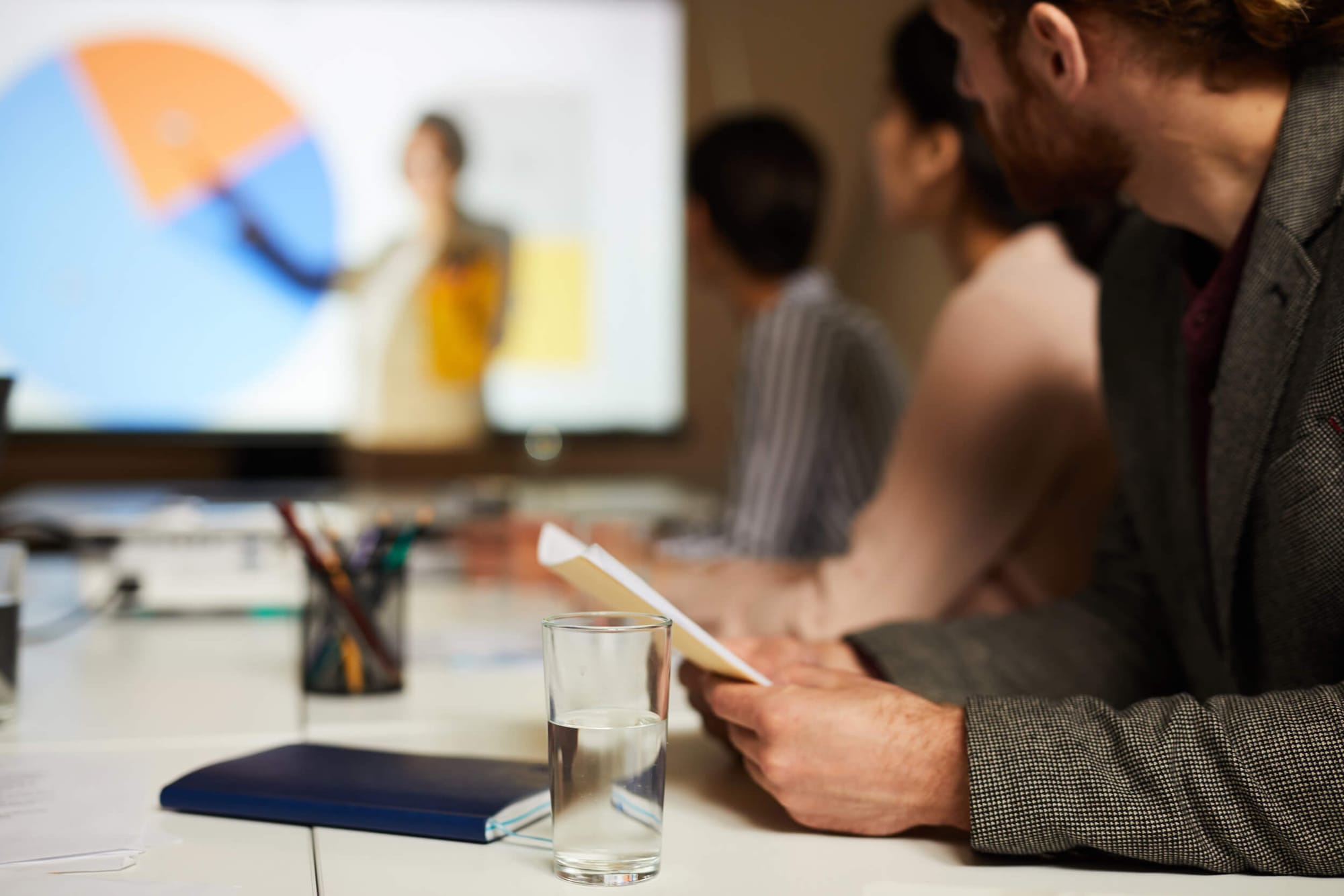 Profissionais reunidos em fórum de negócios discutindo estratégias para treinamentos corporativos e inovação empresarial.