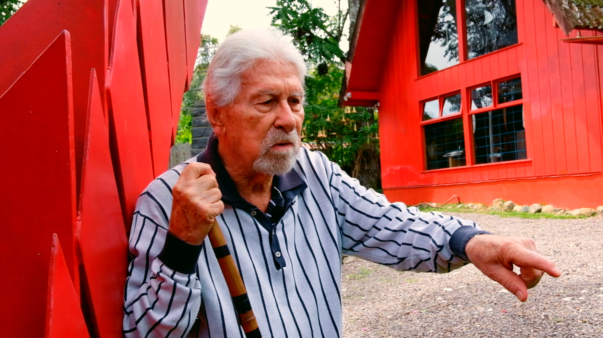 El escultor costarricense José Sancho Benito, junto a su escultura vegetal llamada 'Palmas' [a mano izquierda], hablando de su jardín escultórico.