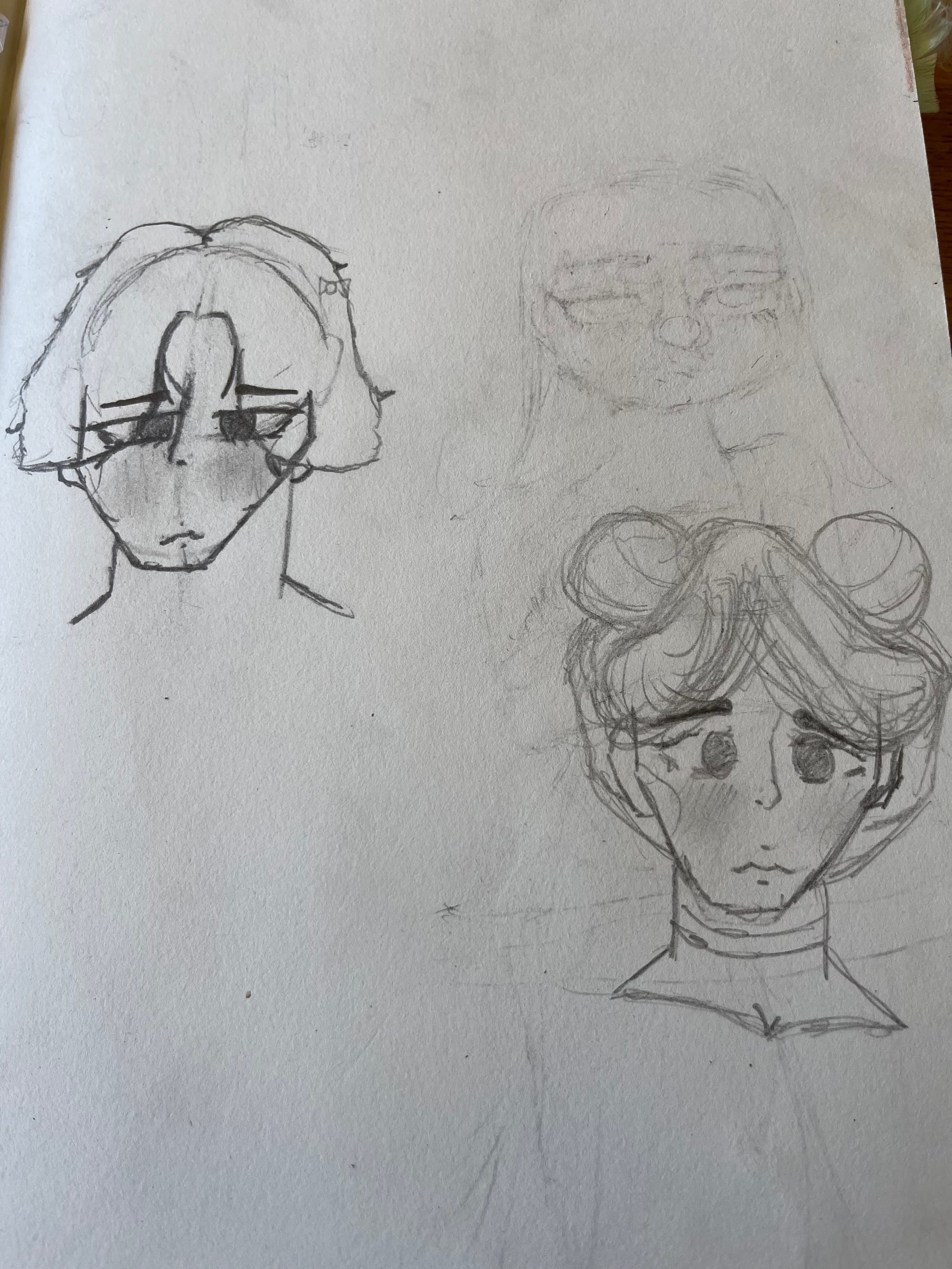 Two hand drawn faces in pencil with sad mouths and downcast eyes