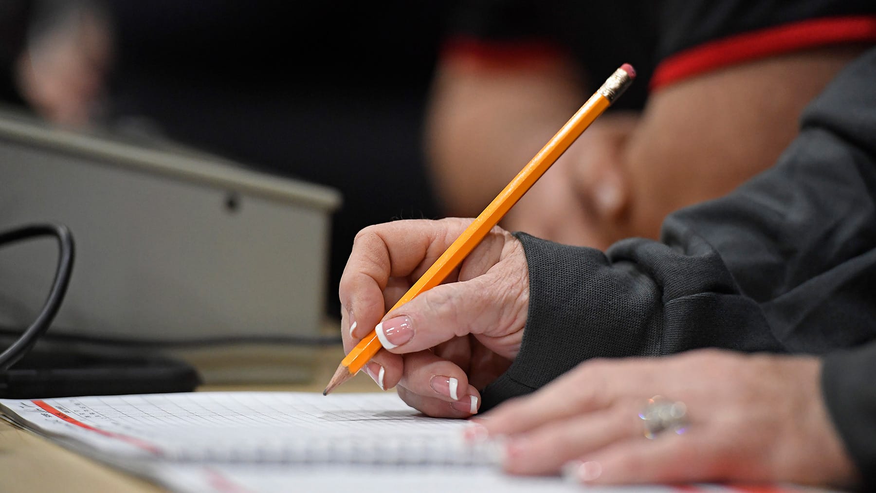 Scorekeeper Angie King Thomas takes down stats as the Santa Fe Raiders face Buchholz Thursday, Dec. 4, 2025, at Santa Fe High School in Alachua, Fla.