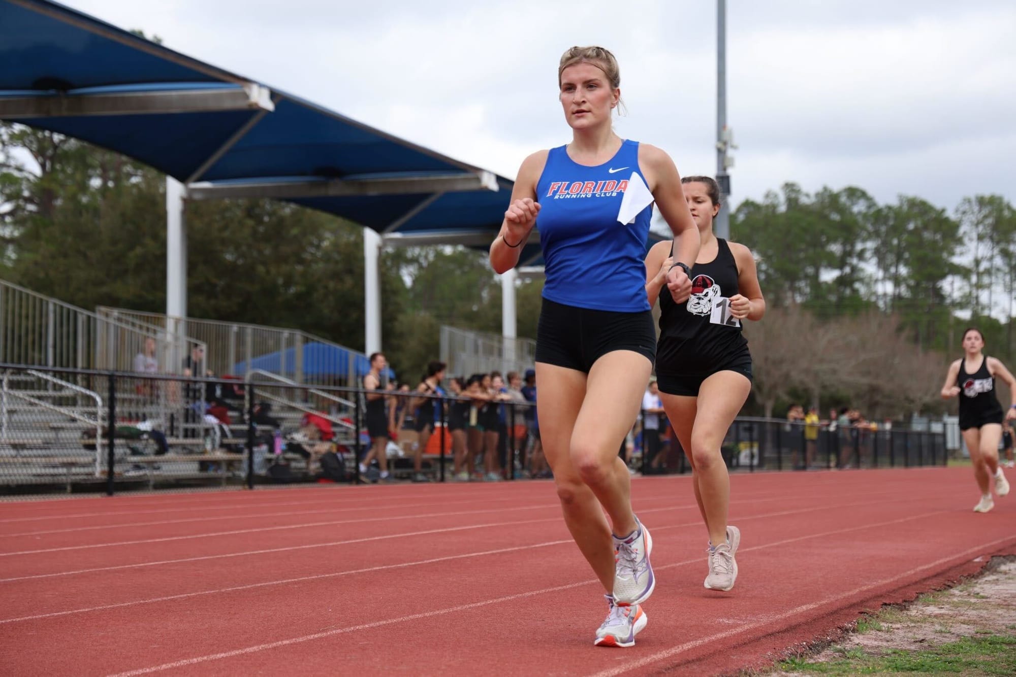 Chloe Reed, the vice president of the running club, runs down the track during a race.