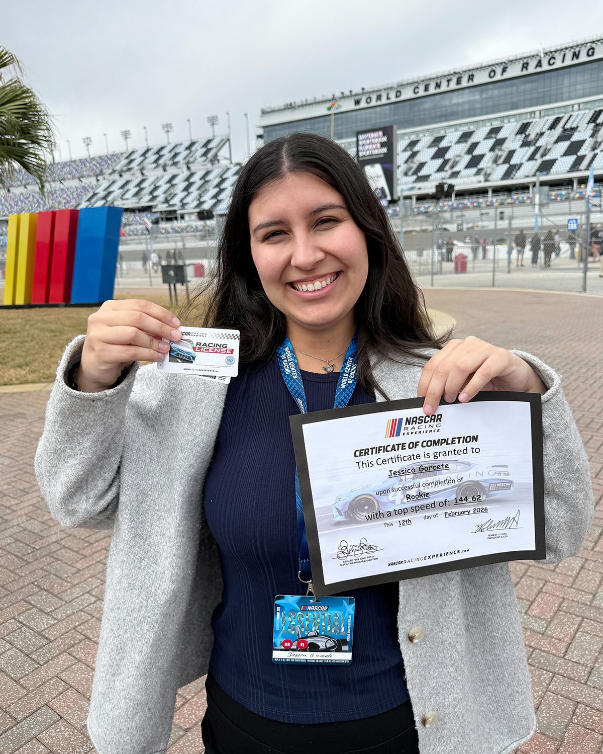 Grandstand Magazine staff writer Jessica Garcete holds the certificate of completion and "racing license" NASCAR Racing Experience participants receive at Daytona International Speedway on Feb. 12, 2026.