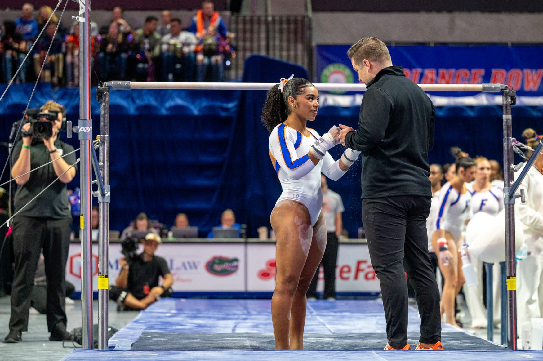 Florida gymnast eMjae Frazier speaks with a coach before her bar routine during an NCAA gymnastics meet against Alabama in Gainesville, Fla., Friday, Jan. 16, 2026.