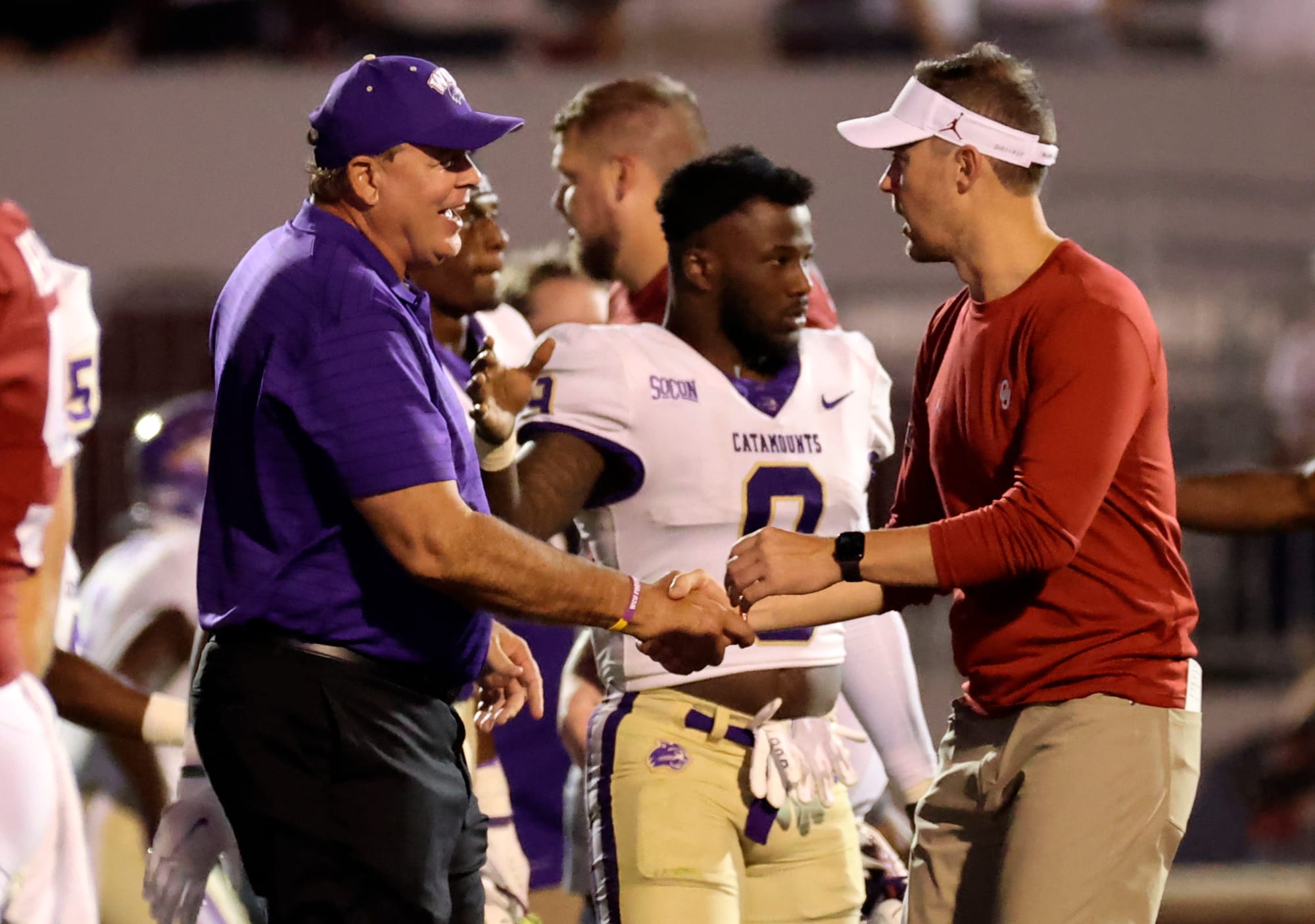 Sep 11, 2021; Norman, Oklahoma, USA; Oklahoma Sooners head coach Lincoln Riley (right) and Western Carolina Catamounts head coach Kerwin Bell (left) shake hands after the game at Gaylord Family-Oklahoma Memorial Stadium. 