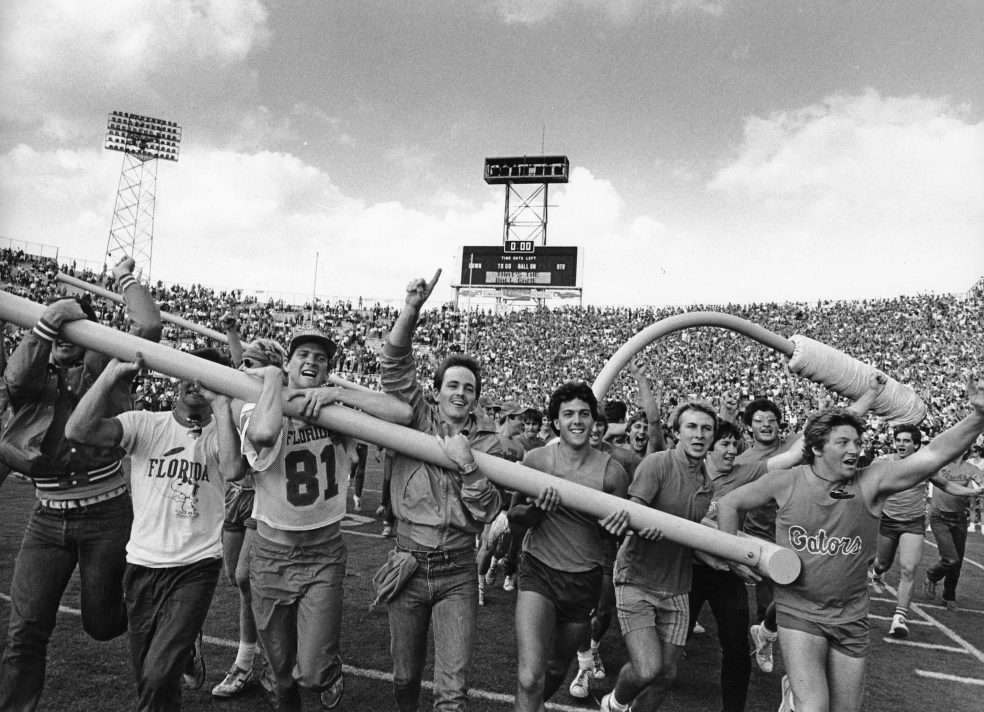 Gator fans take a run around the Gator Bowl field with one of the goal posts following the 1984 Florida-Georgia game.