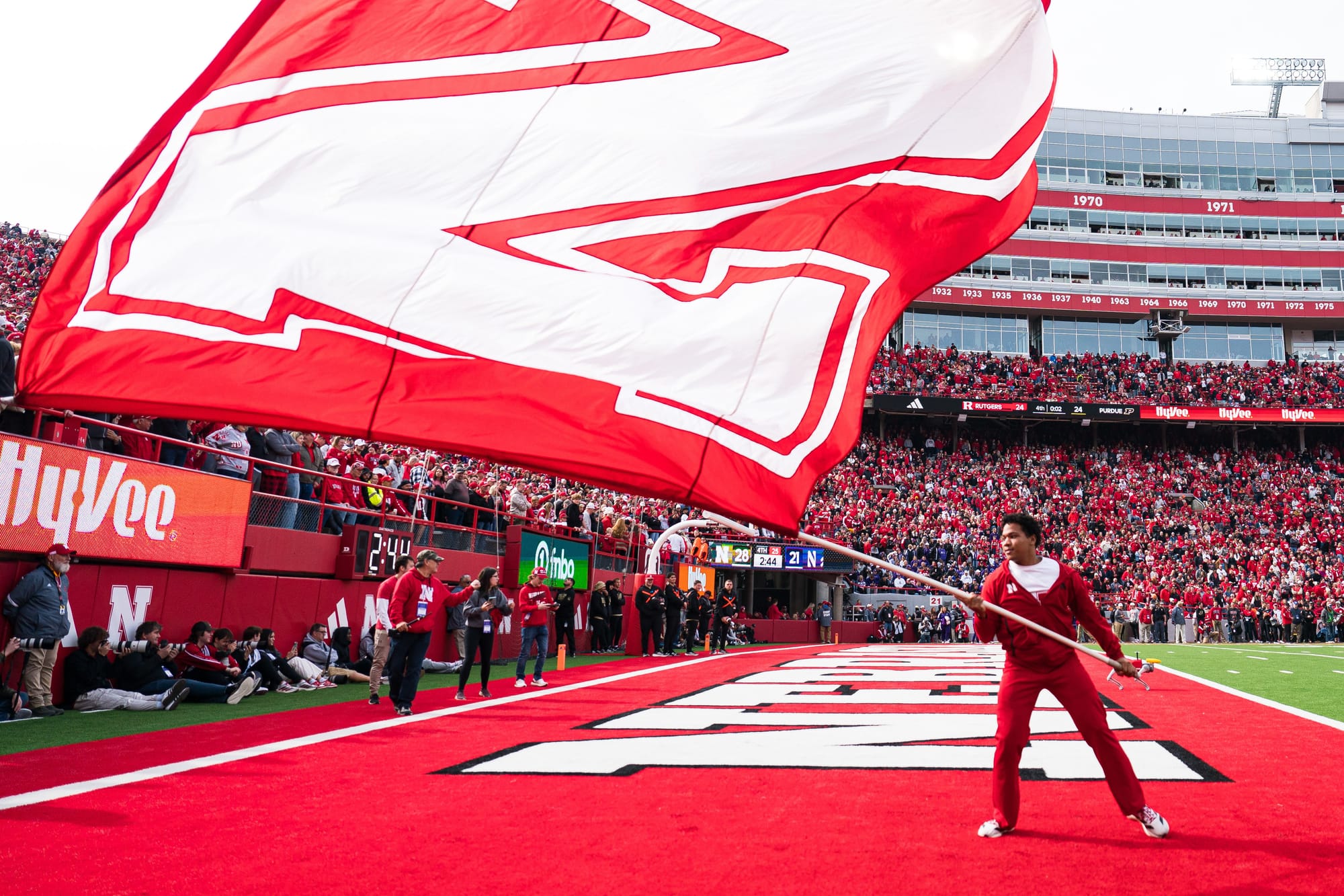 Oct 25, 2025; Lincoln, Nebraska, USA; A Nebraska Cornhuskers cheerleader waves a school flag after a touchdown against the Northwestern Wildcats during the fourth quarter at Memorial Stadium. 