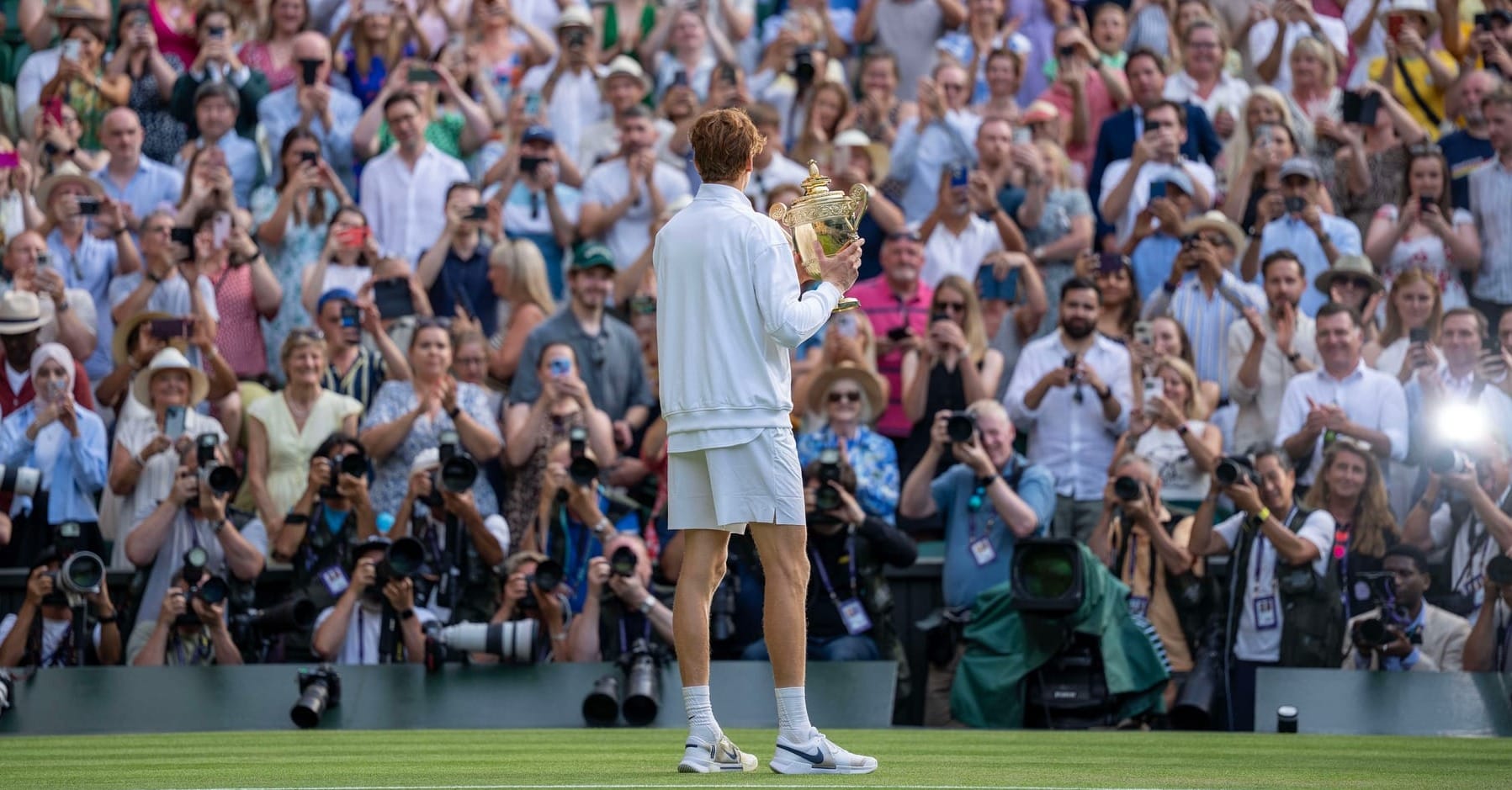 Jul 13, 2025; Wimbledon, United Kingdom; Jannik Sinner of Italy poses with the trophy after winning the men’s singles final match against Carlos Alcaraz of Spain on day 14 at All England Lawn Tennis and Croquet Club.