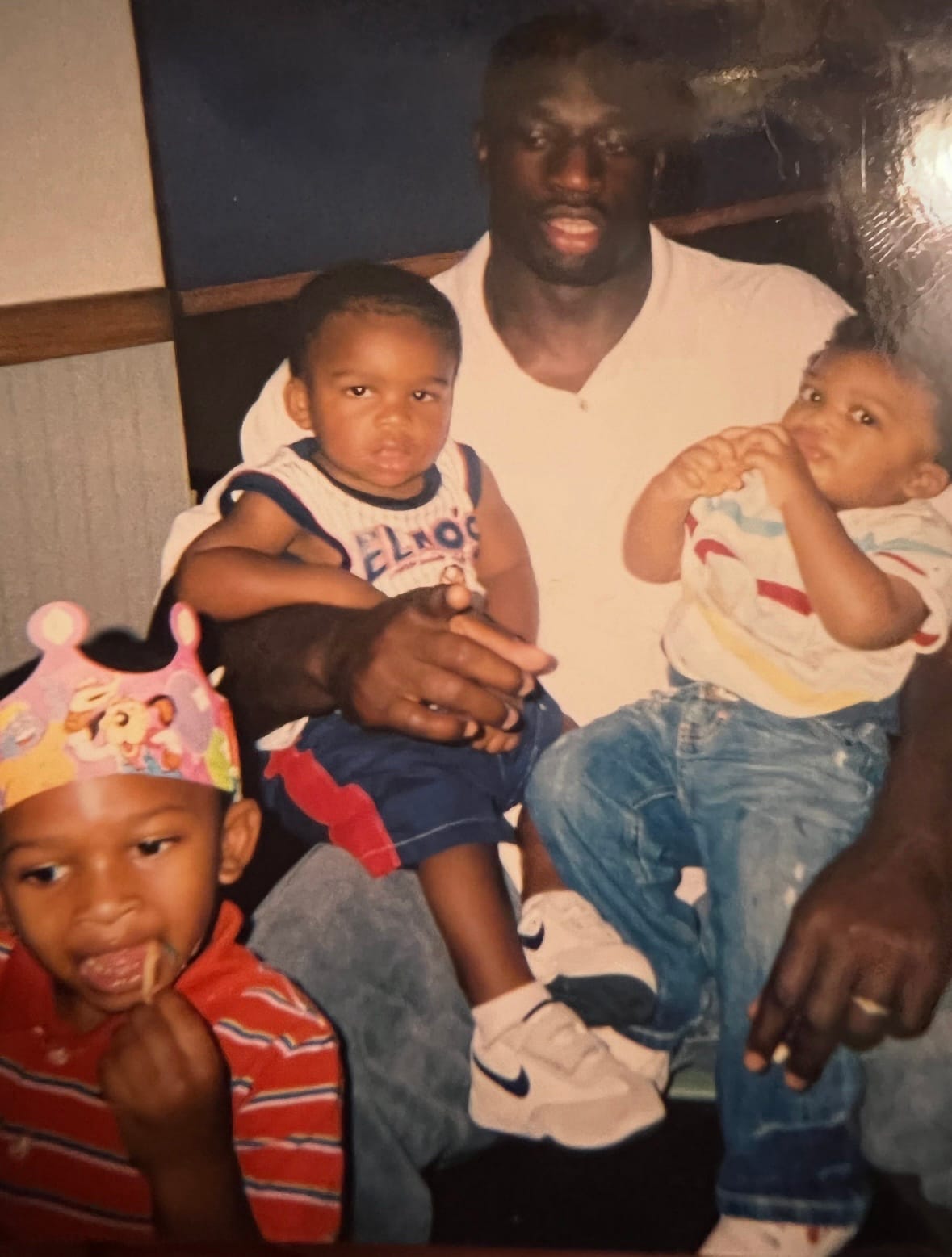 Thaddeus Bullard holds his sons, TJ and Titus, as his daughter stands nearby.