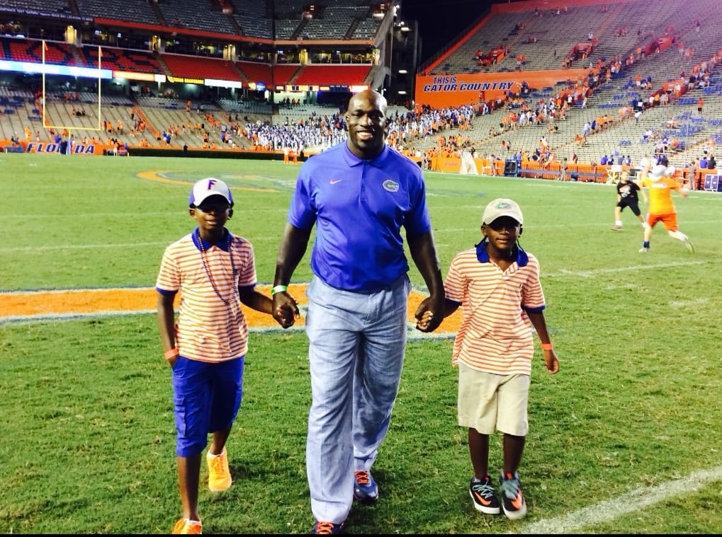 Thaddeus Bullard holds the hands of his sons, TJ and Titus, after a Florida football game at Ben Hill Griffin Stadium in Gainesville, Florida, during the 2010s.