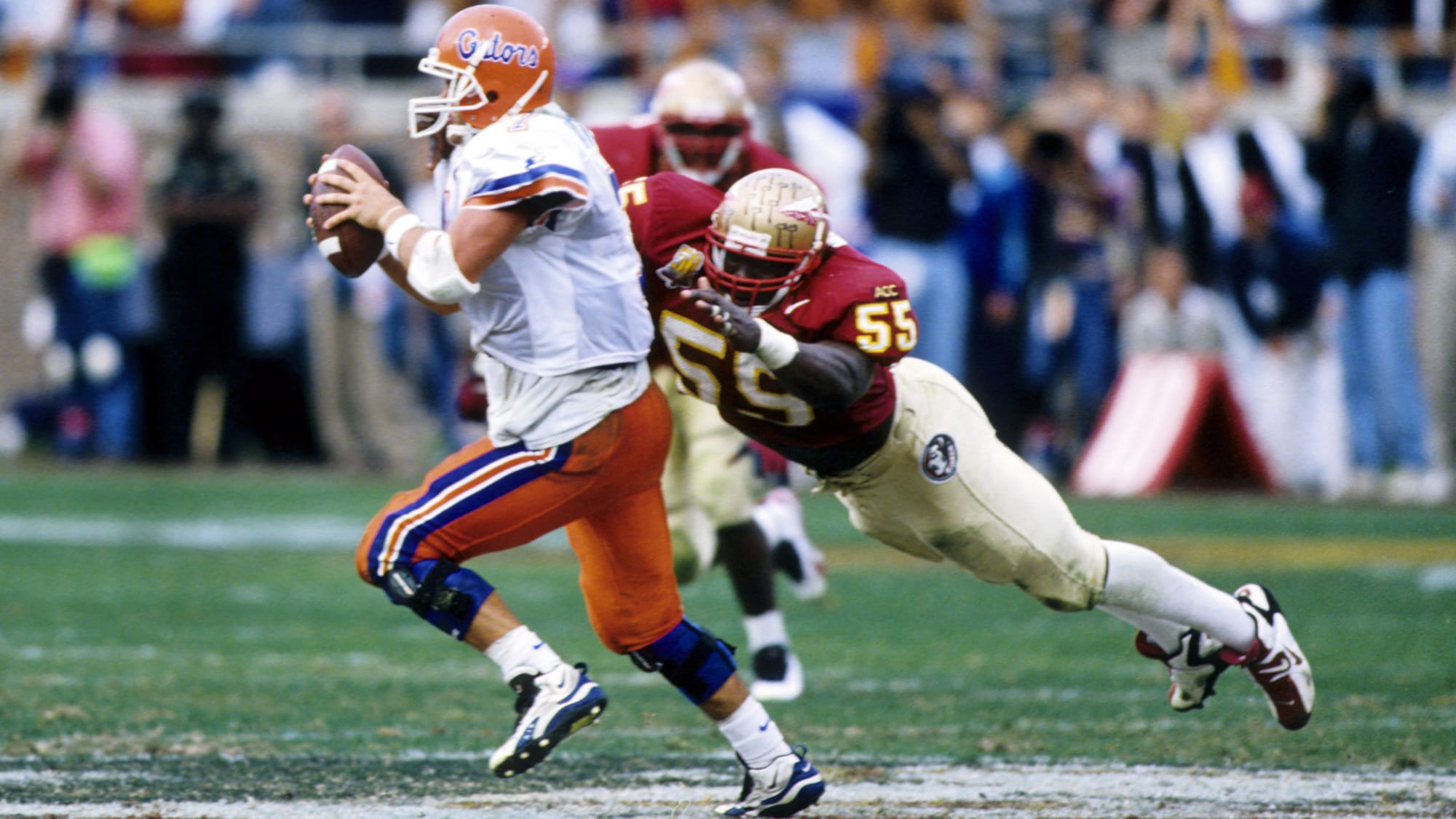 Florida Gators quarterback (7) Danny Wuerffel runs away from the diving tackle of Florida State Seminoles linebacker (55) Reinard Wilson at Doak Campbell Stadium.