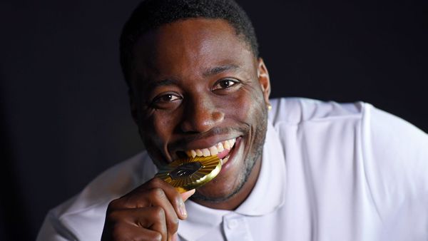 Grant Holloway poses with his 2024 Paris Olympics 110-meter hurdles gold medal during a photoshoot in Weimer Hall at the University of Florida on Feb. 17, 2026.