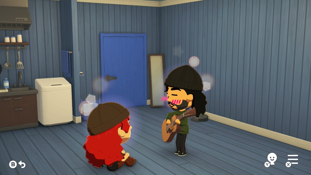 My Mii sits on the ground of Trent's Mii's bedroom. He stands and plays guitar. Both Miis have sparkles around their heads and they are blushing.
