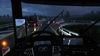 A dashboard screenshot from inside a semi truck. It is raining and dark outside and the windshield wipers are halfway through the windshield.