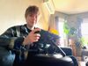 Maddy (the author) poses with her Steam Deck attached to a Mechanism gaming pillow. She is looking at the viewer and smiling slightly