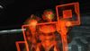 Samus Aran, wearing the orange-red Varia suit, stands in front of a similarly orange-colored data screen. Her eyes and nose can be seen through her helmet's semi-translucent green visor.