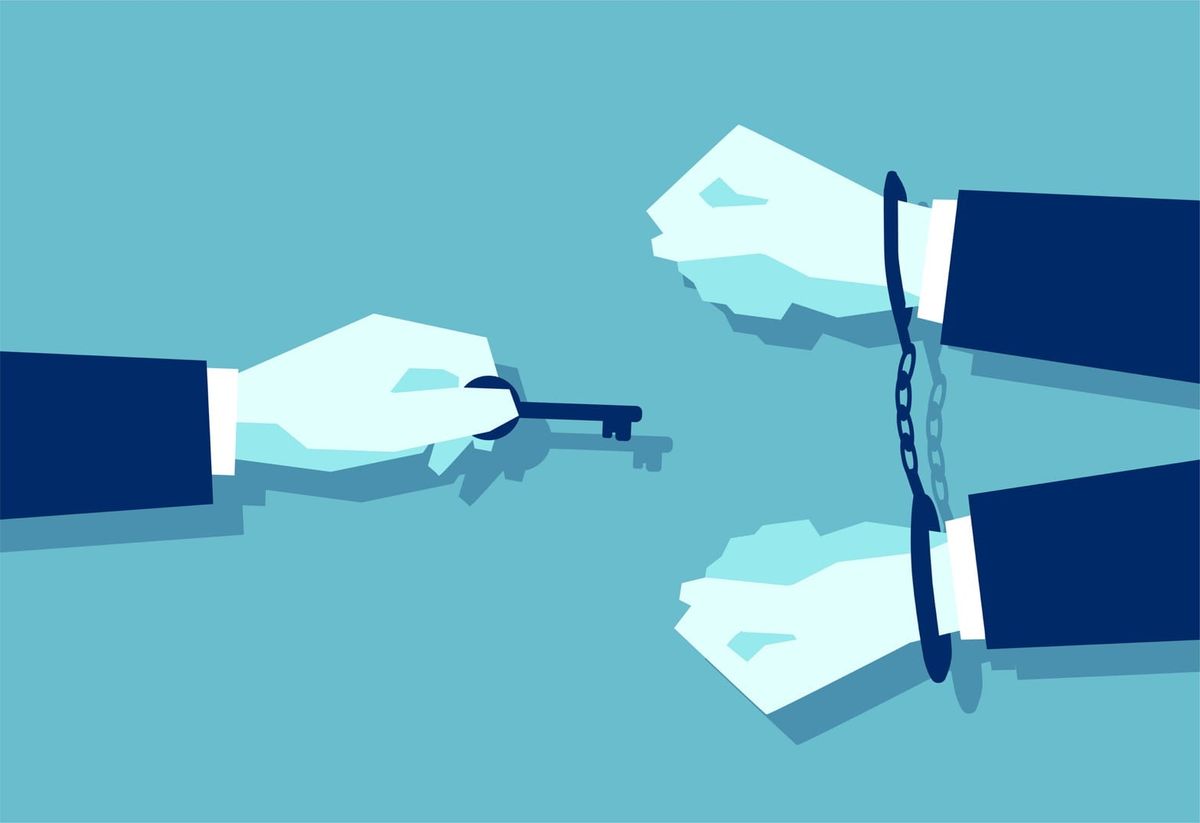 a man with a key reaching out to a man in handcuffs