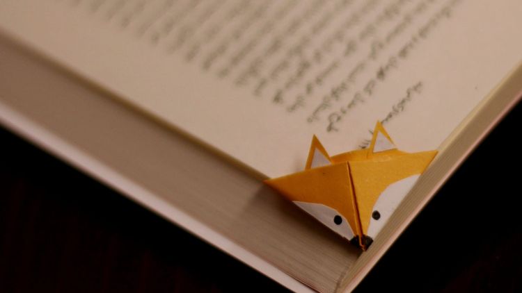 cleverly designed bookmark in the shape of a cute fox head at the corner of a page