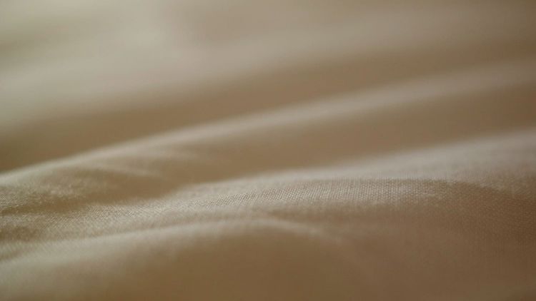 close-up of some beige fabric with gentle folds and shadows across it