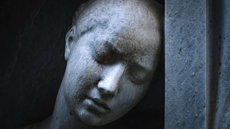close-up view of a melancholy female face on a sculpture