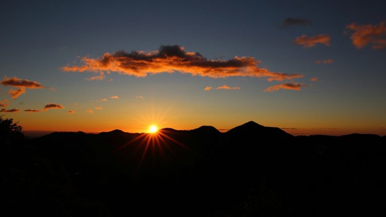 sun beginning to appear over distant hills at dawn