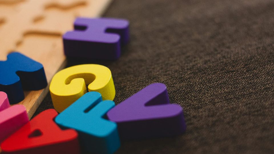 close-up of some colorful alphabet blocks on a carpet
