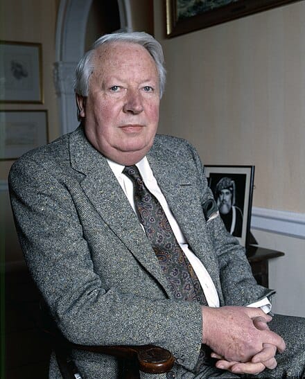 A picture of Ted Heath, former Conservative Prime Minister of the UK, with a paisley pie, white hair and a grey flecked suit. 