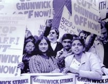 Men and women film processing workers hold up signs at a picket.