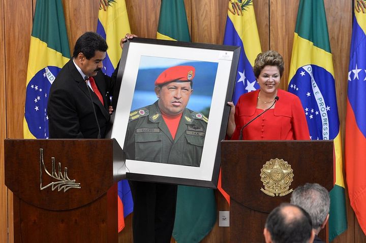 Nicholás Maduro holds a picture of Hugo Chávez, handed to him by Dilma Rousseff, former president of Brazil