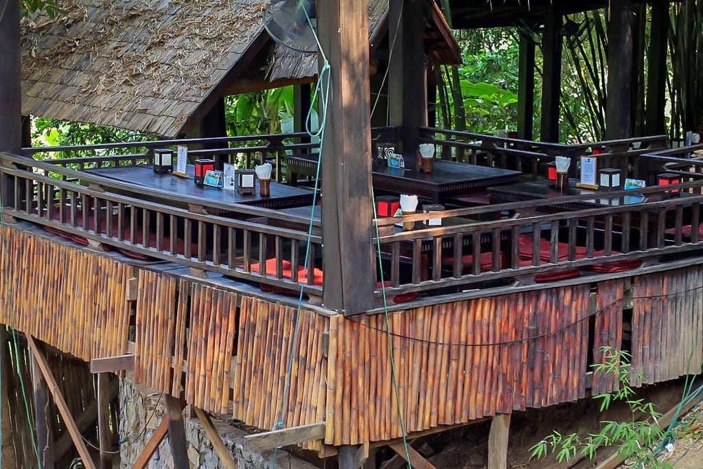 Restaurant en plein air avec toit de chaume entouré de végétation tropicale à Luang Prabang
