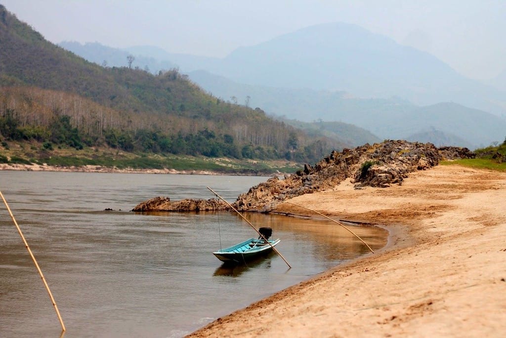 Misty morning sunrise over the Mekong River with mountains in the background