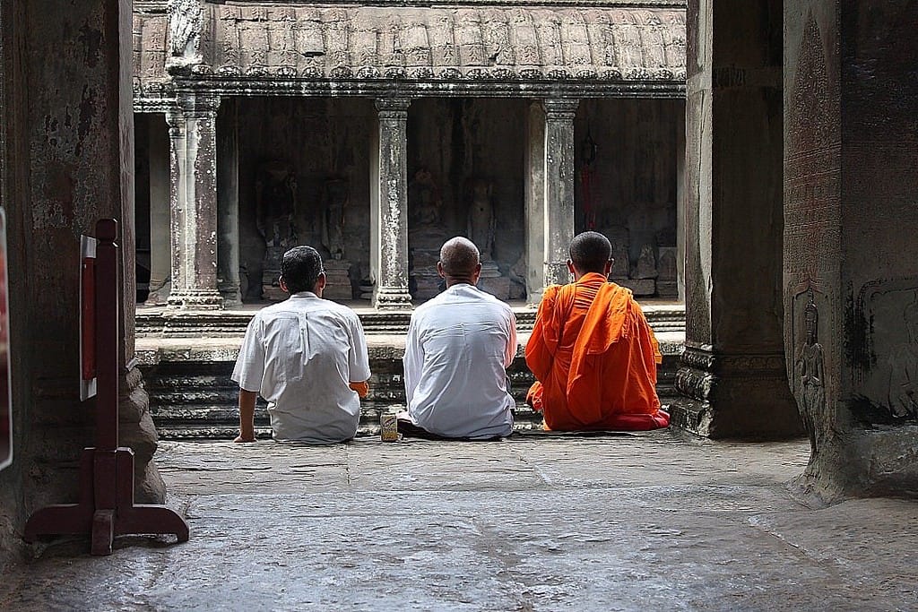 Buddhist monks in orange robes walking at Angkor Wat temple in Siem Reap, Cambodia
