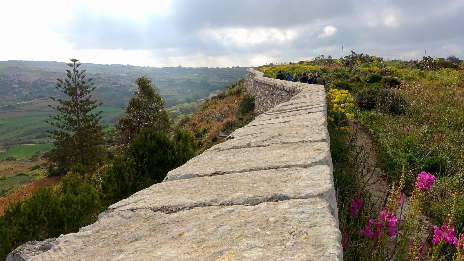 Walking the Victoria Lines trail with panoramic views across northern Malta countryside