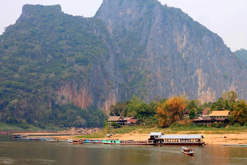 Panoramic view of misty green mountains and the Mekong River from the slow boat deck in Laos