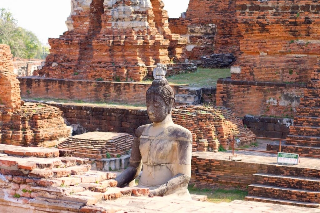 Ruines anciennes du temple Wat Maha That à Ayutthaya avec colonnes de pierre et statues de Bouddha