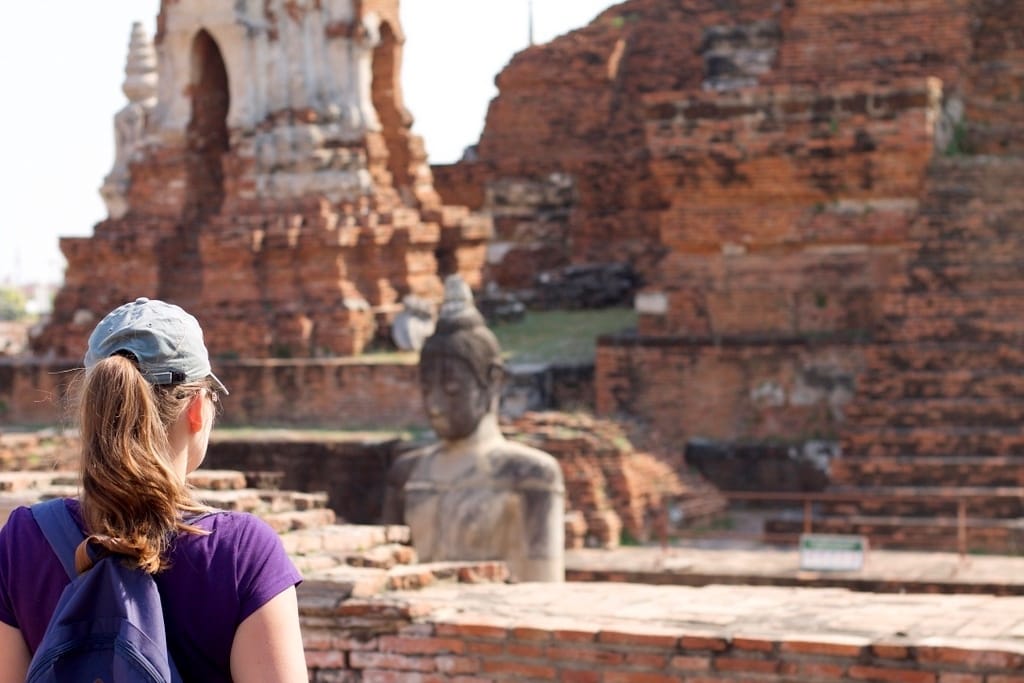 Voyageuse admirant la célèbre tête de Bouddha dans les racines d’arbre au Wat Maha That Ayutthaya