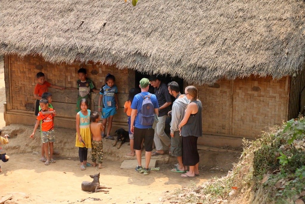 Local children from a tribal village along the Mekong River greeting slow boat passengers