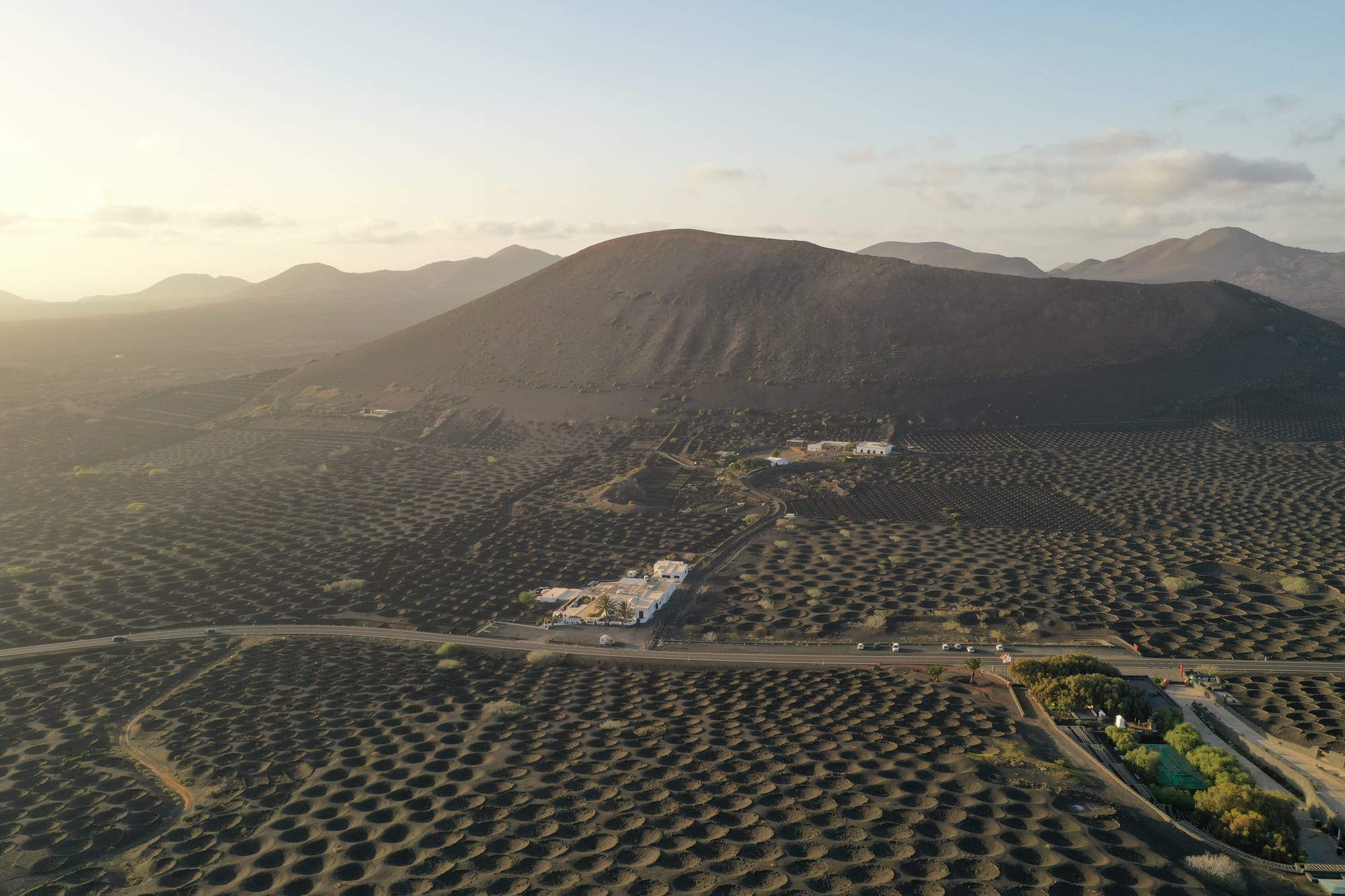 Aerial view of Puerto del Carmen harbour with colourful fishing boats, golden beach and the volcanic interior of Lanzarote in the background — Lanzarote