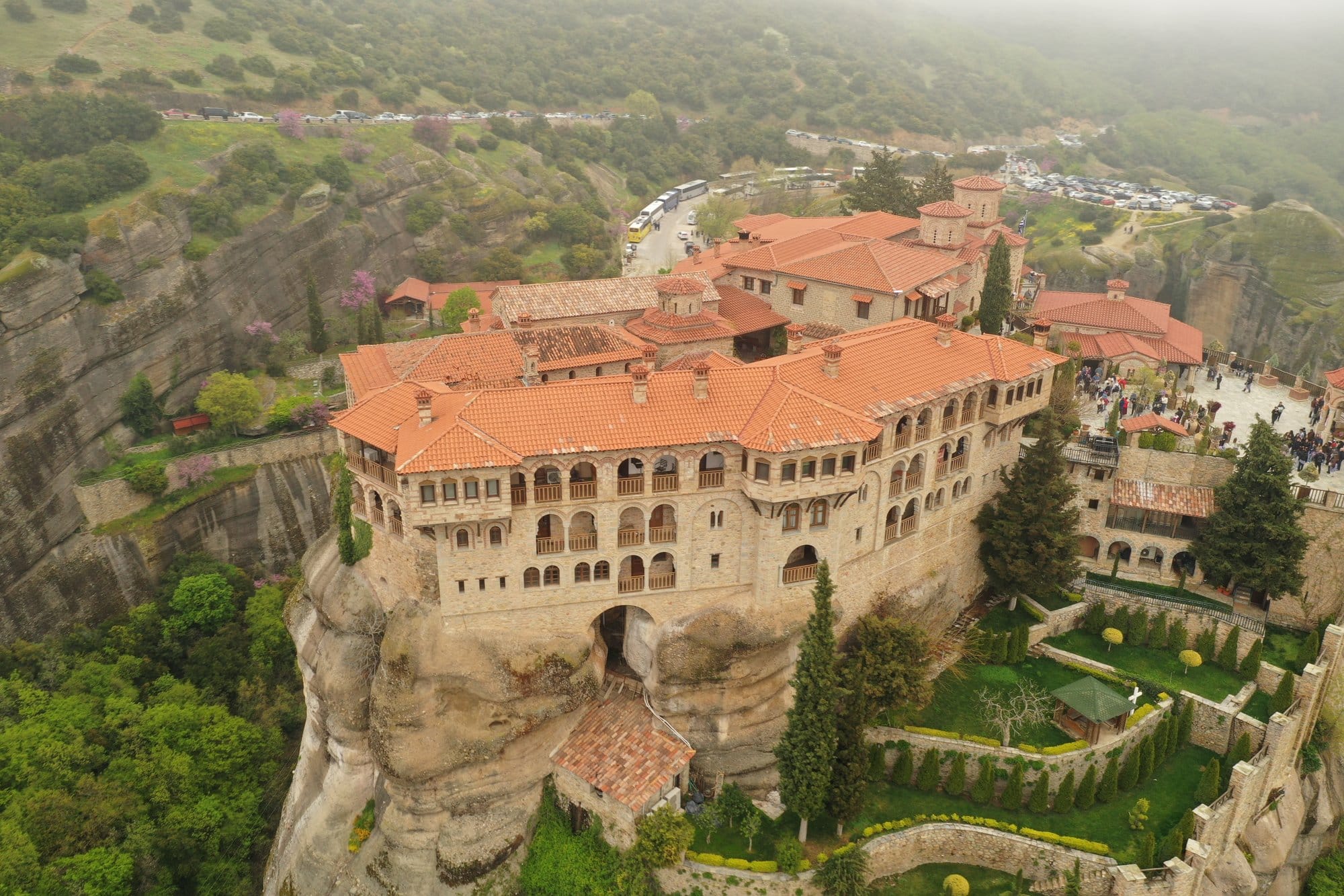 Aerial of a Meteora monastery under low mist and overcast sky — Greece