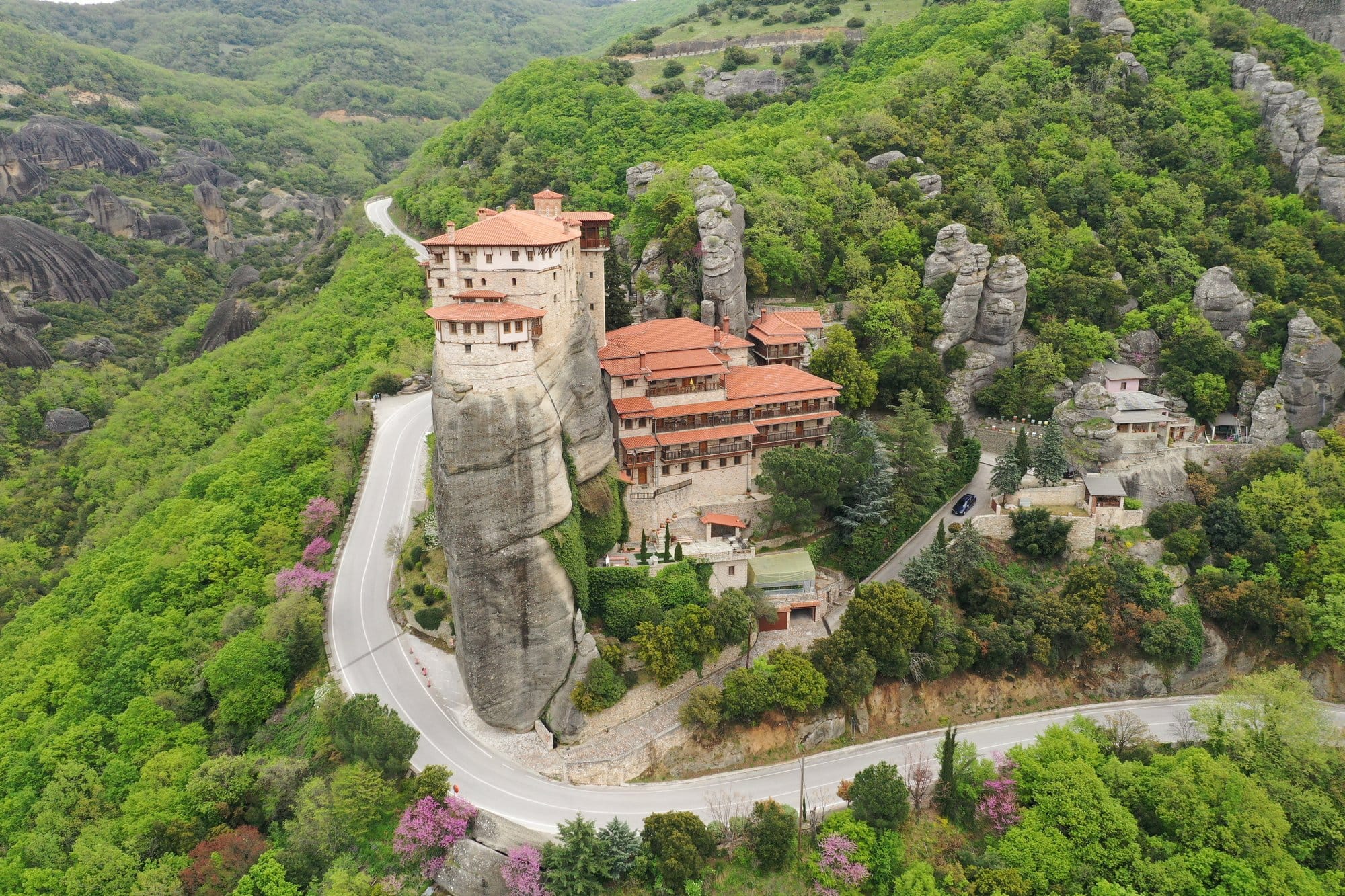 Vue aérienne d'un monastère de Meteora avec sa route d'accès qui serpente autour du rocher — Grèce