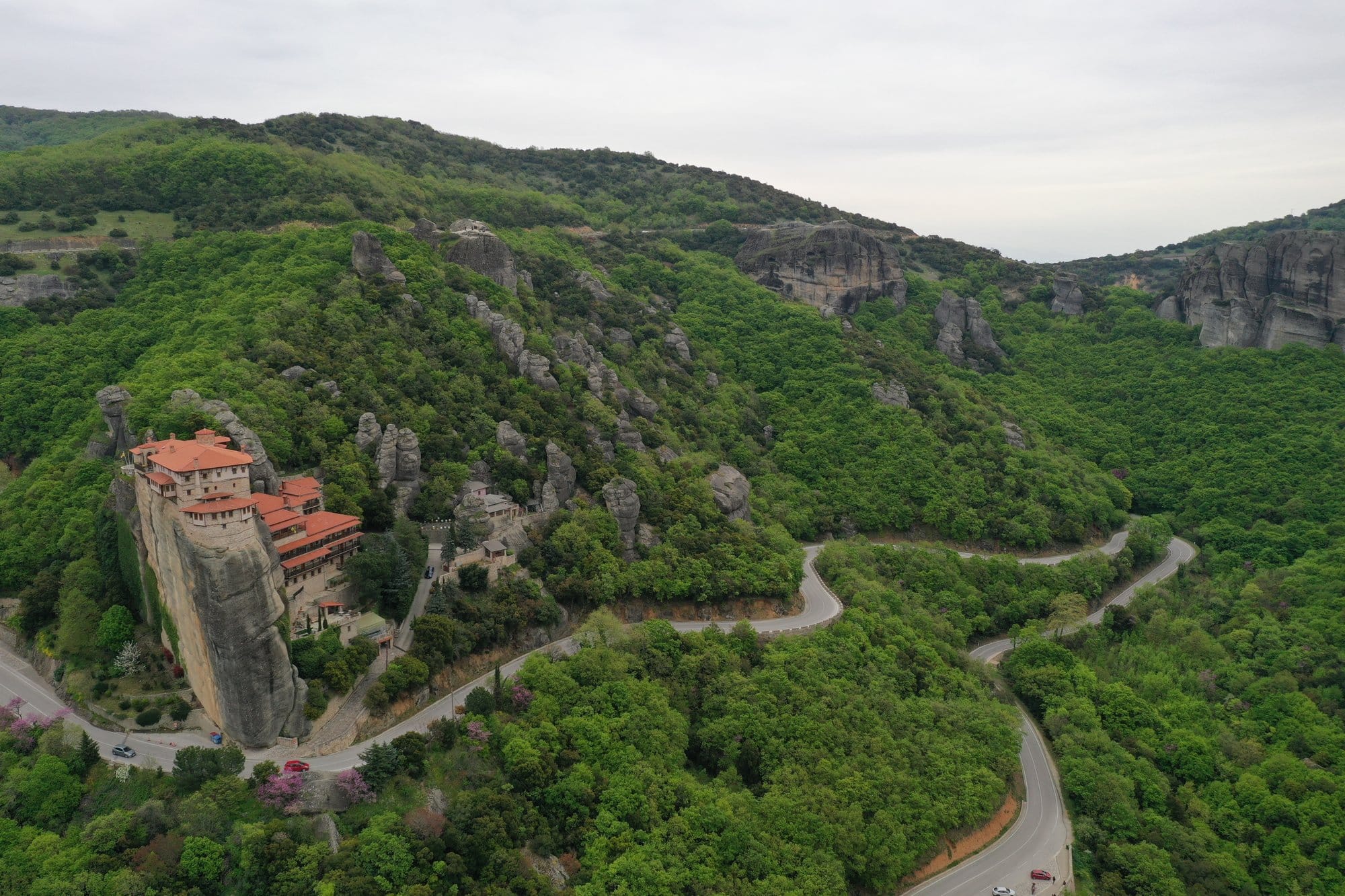 Vue aérienne d'un monastère de Meteora sur un rocher avec la route d'accès visible en dessous — Grèce