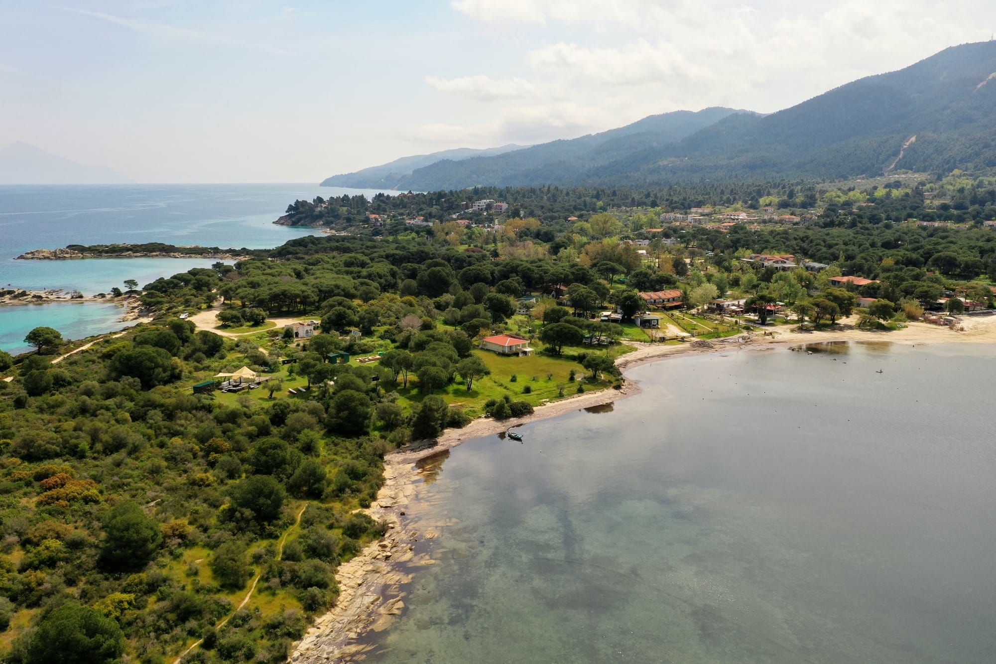 Vue aérienne d'une crique de Sithonia avec cap boisé de pins et eau turquoise — Grèce