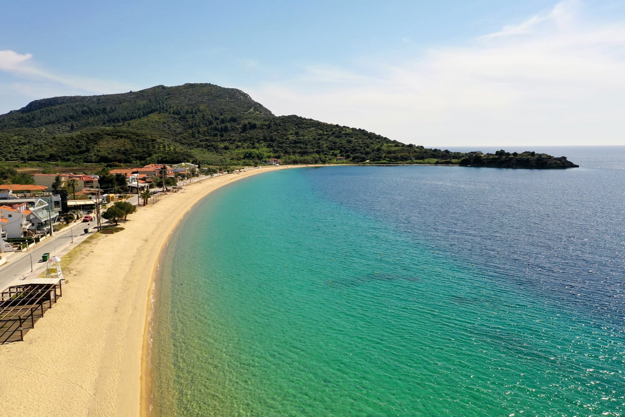 Vue aérienne d'une longue plage de Sithonia avec sable doré en courbe et collines derrière — Grèce