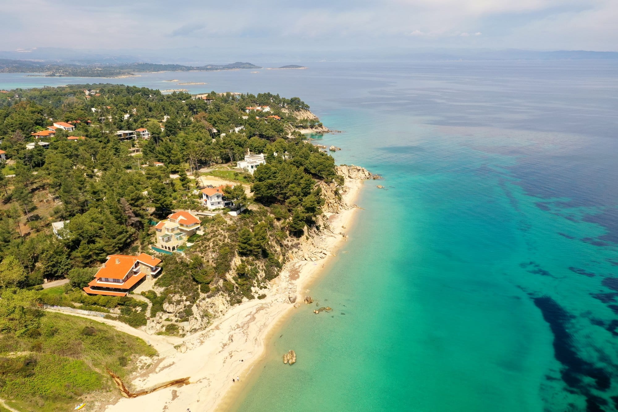 Vue aérienne d'une côte de Sithonia avec pins, une villa et de l'eau turquoise — Grèce